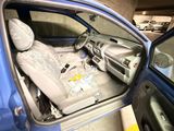l'intérieur d'une voiture, la portière ouverte et le siège relevé