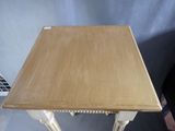 a small table with a wooden top and white legs