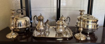 un plateau en argent sur lequel sont posés des objets en argent, posé sur une table