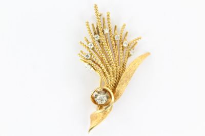un gros plan d'une broche en or sertie d'un diamant