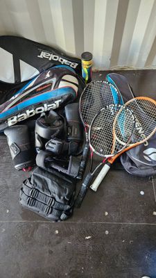 many tennis rackets, gloves, and a ball on the floor