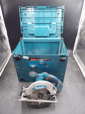 une boîte à outils bleue et une scie circulaire posées par terre
