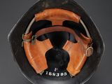 an old baseball helmet with a baseball mitt on top of it