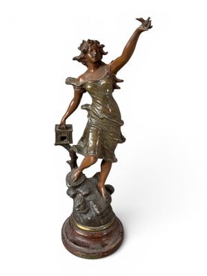 statue en bronze d'une femme tenant un oiseau sur un piédestal