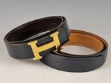 a pair of black and brown leather belts with a gold h buckle