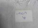 a picture of a bed with a white sheet and a sign on it