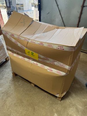 un grand carton posé sur une palette dans un entrepôt
