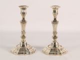 pair of silver candlesticks on a white surface with a white background