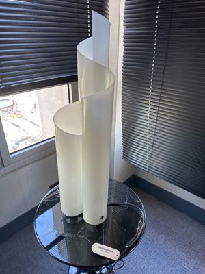 une table en verre sur laquelle est posée une bougie, devant une fenêtre