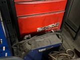 a red tool box and a blue tool box in a garage