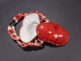 a red heart shaped box sitting on a black surface