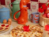 une figurine de chien posée à côté d'une tarte sur une table