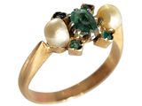 une image montrant un gros plan d'une bague ornée de perles et d'émeraudes