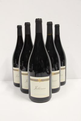 four bottles of wine are lined up on a white surface