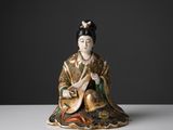 une figurine chinoise représentant une femme jouant d'un instrument de musique