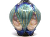 a blue and green vase with a shell design on it