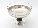 a glass bowl with a wooden base on a white surface