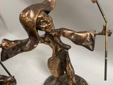 bronze figurine of a man holding a broom and a hat