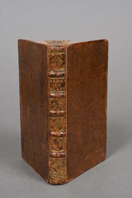an old book with a brown cover sitting on top of a table