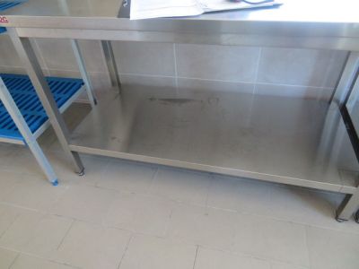 une table en acier inoxydable avec deux tabourets en plastique bleu