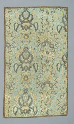 a close up of a blue and green rug on a gray surface