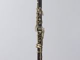 a black and gold clarinet sitting on top of a clear stand
