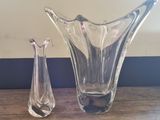 two glass vases sitting on a table next to each other
