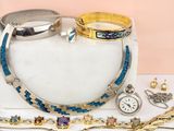 de nombreux bijoux posés sur une table blanche, sur fond rose