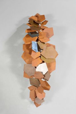 une sculpture réalisée à partir de cartons posée sur une surface blanche