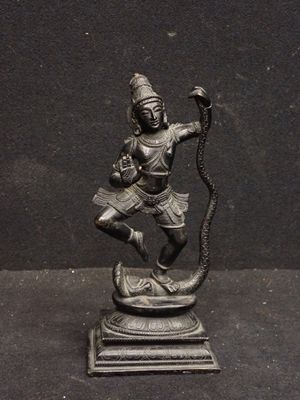 statue en bronze représentant une personne tenant un serpent, posée sur un socle