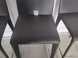 three black leather bar stools sitting next to each other in a room