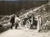 people standing around a horse drawn carriage on the side of the road