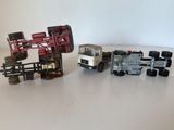 trois camions miniatures posés les uns à côté des autres sur une table