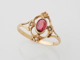 une bague en or sertie d'une pierre rouge et de perles