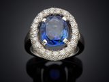 an oval blue sapphire and diamond ring on a black surface