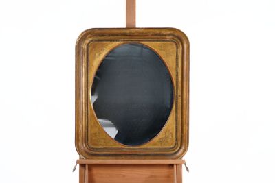 a wooden clock with a mirror in the middle of it