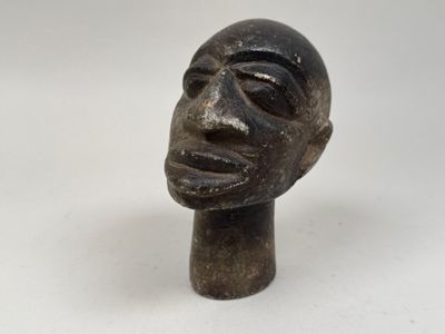 une image représentant une sculpture représentant une tête d'homme sur une surface blanche