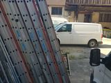a white van parked in front of a building with a bunch of ladders on it