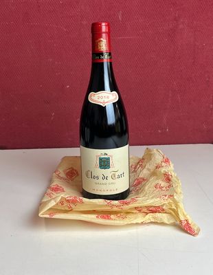 Plusieurs bouteilles de vin sont posées sur une table, à côté d'une serviette