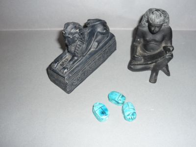 une petite statue représentant un homme assis sur un banc à côté d'une paire de chaussures
