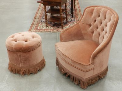 un fauteuil et un pouf dans une pièce où se trouve un tapis