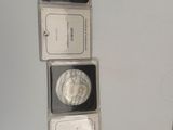 three silver coins are sitting on top of each other on a table