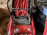 an image of a red air compressor sitting on top of a metal shelf