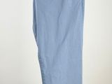 blue pants hanging on a hanger against a white wall