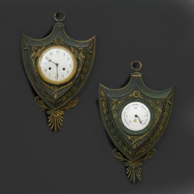 pair of antique wall clocks on a black background with a dark background