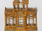 a small wooden bird cage with a clock on top of it