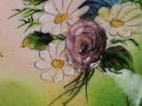 a plate with flowers painted on it sitting on a table