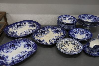 de nombreuses assiettes et bols bleus et blancs sur la table