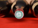 several bottles of wine are lined up on a red cloth