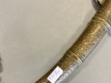 an old dagger with a gold handle on a white table